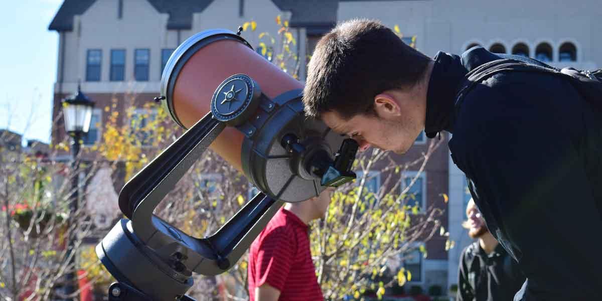 一个学生在天文学课上用望远镜看东西
