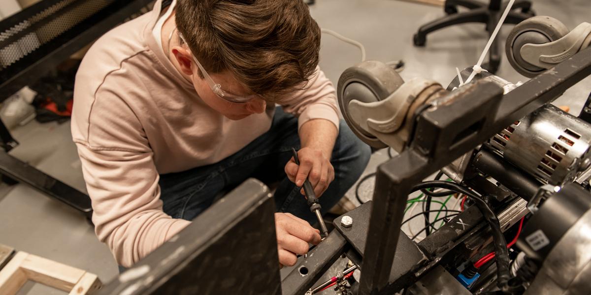 机械工程专业的学生用螺丝刀修理机器