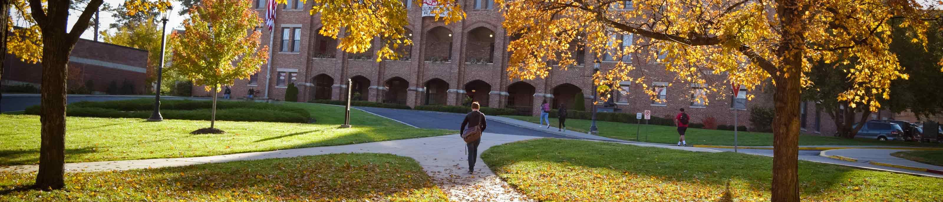 一名学生走在秋季的本尼迪克特学院校园里